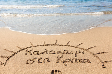 Hand made text in sand on a beach - Καλοκαίρι στη Κ