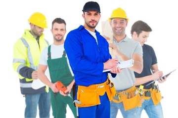 Composite image of handyman in blue overall writing on clipboard