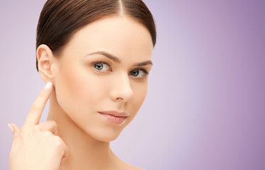 Naklejka premium face of beautiful woman touching her ear