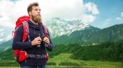man with backpack and binocular outdoors