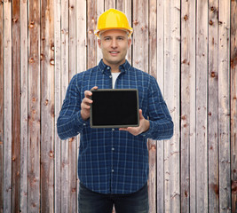 smiling male builder in helmet with tablet pc