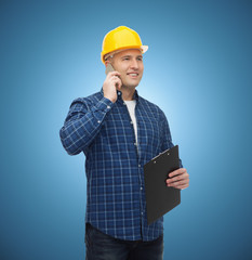 smiling male builder in helmet with clipboard