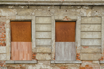 Obraz na płótnie Canvas windows of an old abandoned building closed with wooden boards
