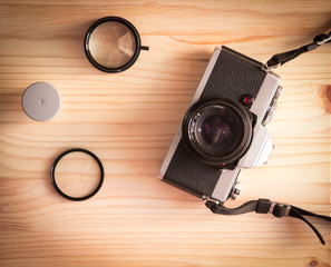 vintage old photo camera with roll and lenses on a wooden table