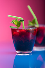 Raspberry and blackberry cocktail with mint garnish. Studio shot