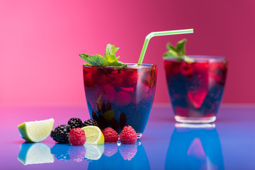 Raspberry and blackberry cocktail with mint garnish. Studio shot