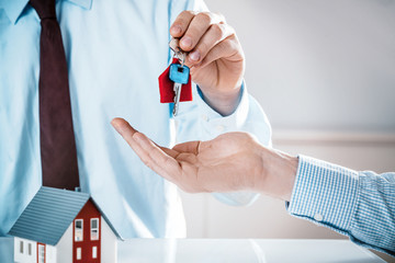 Conceptual Agent Giving House Key to a Buyer