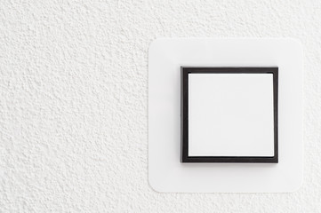 Light switch on white wall, detail shot with copy space