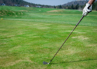 Obraz premium A hand is holding a golf club and measuring the Trajectory. Gree