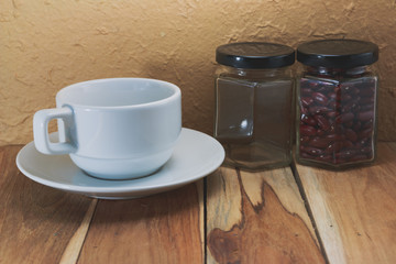 White coffee cup, jar and red beans on a wooden. Process color w