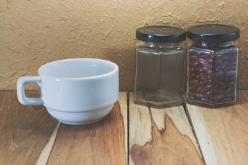 White coffee cup and Empty jar on a wooden. Process color with v