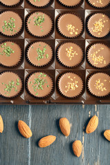 Tasty chocolate candies with almond on wooden table