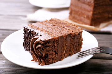 Tasty pieces of chocolate cake on wooden table background