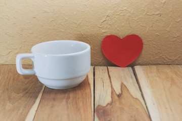 Coffee cup and red heart on a wooden. Process color with vintage