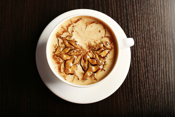 Cup of latte on wooden table, top view