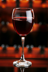 Glass of red wine on bar background