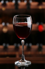 Glass of red wine on bar background