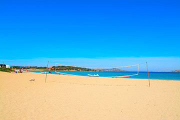 Fototapeta na wymiar beach volley net and rubber boats in Porto Pollo