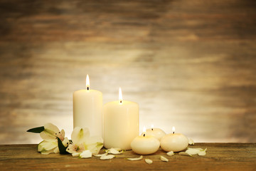 Fototapeta na wymiar Candles with flowers on wooden background