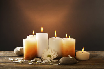 Fototapeta na wymiar Candles with chrysanthemum on wooden background