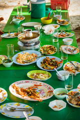 Remaining plates leftover on the table with remaining Thai food