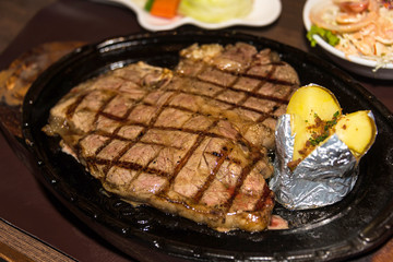 Premium American prime rib steak on a metal plate.
