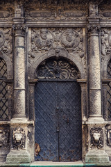 Black metal doors and two pillars on each side in a church