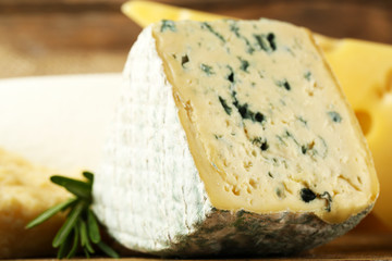 Different sort of cheese on wooden table, closeup