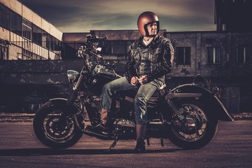 Biker and his bobber style motorcycle on a city streets © Nejron Photo