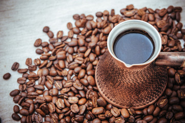 Coffee turk and roasted beans on burlap background.