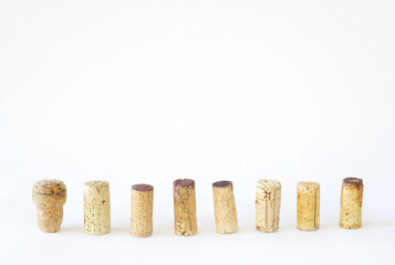 row of wine corks on white background