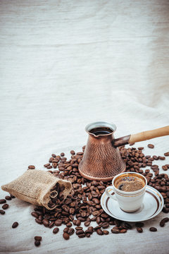 Coffee turk and roasted beans on burlap background.