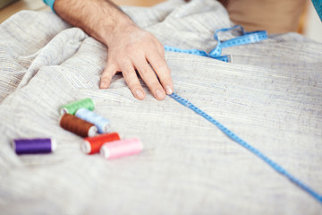Obraz na płótnie Canvas Designer measuring textile material