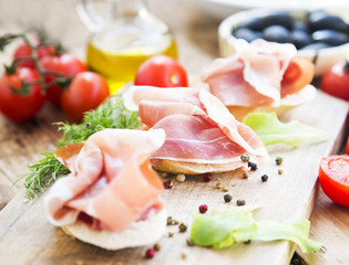 Prosciutto Ham Appetizer with Spices on a Wooden cutting Board