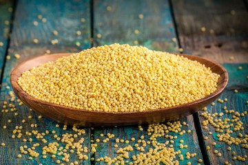 organic millet seeds in a wooden bowl
