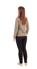 back view of standing young beautiful  woman in jeans.
