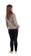 back view of standing young beautiful  woman in jeans.