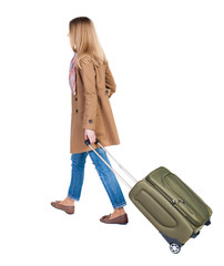 back view of walking  woman  with suitcase. beautiful girl in mo
