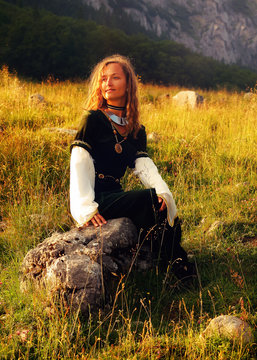 Mystical Medieval Maiden Sitting On A Wild Meadow Stone 