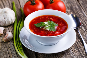 Borsch with bread on a wooden background.