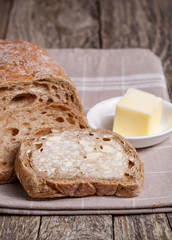 Tasty bread with wheat on wooden background.