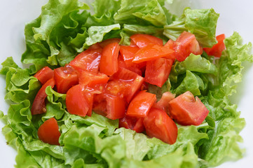 Healthy green salad, tomatoes in white bowl