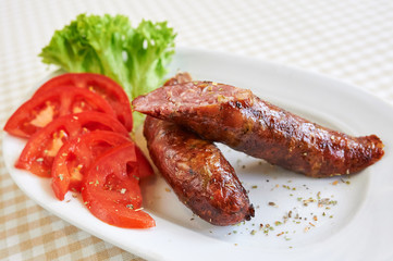 Grilled sausages with fries and vegetables