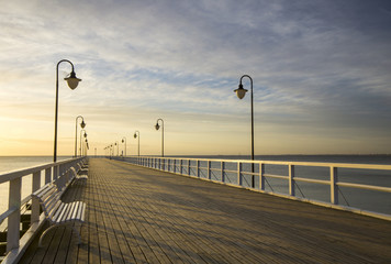 Fototapeta premium Drewniane molo nad Morzem o wschodzie słońca