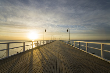 Fototapeta na wymiar Drewniane molo nad Morzem o wschodzie słońca