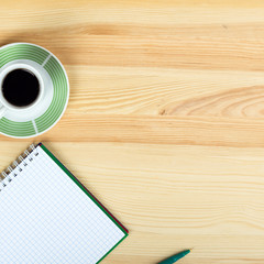 notebook pen and cup of coffee in wood table