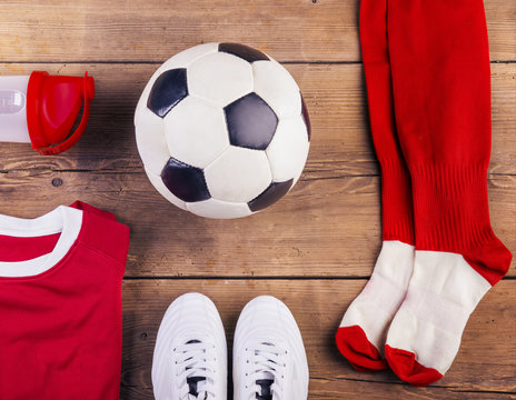 Various football stuff lined up on a wooden floor background