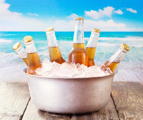 cold bottles of beer in bucket with ice © Nitr