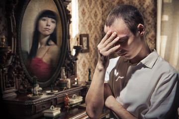 Fototapeta na wymiar Man in grief on the vintage mirror background