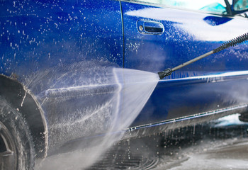 Blue car wash using high pressure water jet.